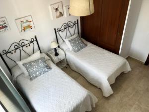 ein Schlafzimmer mit zwei Betten und einer Lampe in der Unterkunft Ático Barrio de los Pescadores in Costa Ballena + 22 Fotos