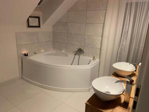 a white bathroom with a tub and a sink at Willa na Mazurach Ametyst in Szczytno