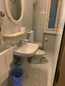 a bathroom with a sink and a toilet and a mirror at Nuovo Hotel Attico in Chianciano Terme