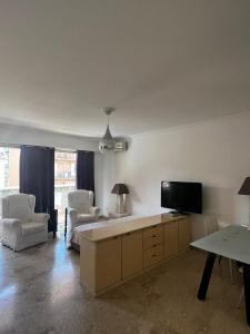 a living room with a flat screen tv and chairs at Monaco Studio "907" in Monte Carlo
