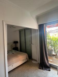 a bedroom with a bed and a large window at Monaco Studio "907" in Monte Carlo