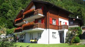 a house with flowers on the balconies of it at Bel-Häx in Blatten bei Naters