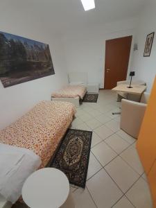 a room with three beds and a table and a desk at Lunga Via Delle Dolomiti in Calalzo