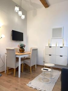 a dining room with a table and chairs and a tv at Casa Luna, tu oasis en mejor barrio de Madrid in Madrid
