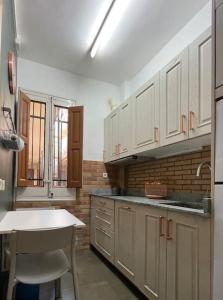 a kitchen with white cabinets and a table in it at Casa Luna, tu oasis en mejor barrio de Madrid in Madrid
