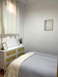 a white bedroom with a bed and a dresser at Casa Luna, tu oasis en mejor barrio de Madrid in Madrid