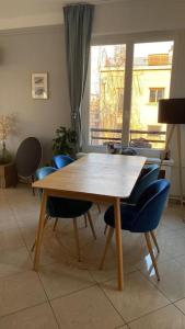 - une table et des chaises en bois dans le salon dans l'établissement Superbe appartement lumineux, à Neuilly-sur-Seine