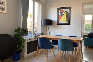 une salle à manger avec une table en bois et des chaises bleues dans l'établissement Superbe appartement lumineux, à Neuilly-sur-Seine