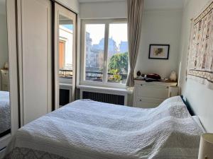 - une chambre avec un lit et une fenêtre dans l'établissement Superbe appartement lumineux, à Neuilly-sur-Seine