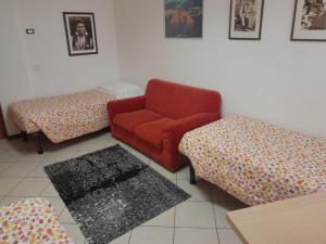 a living room with a red couch and two ottomans at Lunga Via Delle Dolomiti in Calalzo