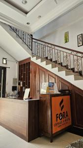 a lobby with a reception desk and a staircase at Fora Capsule Hostel Tuban Kuta Bali in Kuta +5 photos