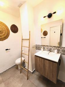 ein Badezimmer mit einem Waschbecken, einem WC und einem Spiegel in der Unterkunft Medina Marinas - Tú hogar con solarium privado! in Vera