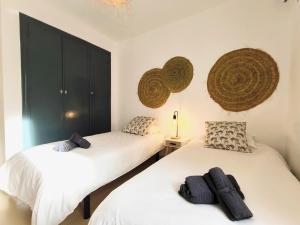 2 Einzelbetten in einem Zimmer mit schwarzen Schränken in der Unterkunft Medina Marinas - Tú hogar con solarium privado! in Vera