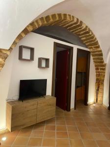 uma sala de estar com uma televisão de ecrã plano e um arco em Casa Carini em Sciacca