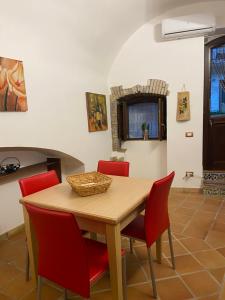 comedor con mesa de madera y sillas rojas en Casa Carini, en Sciacca