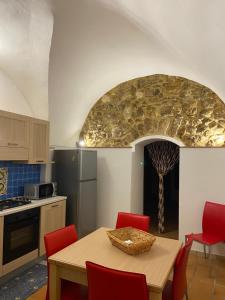 Casa Carini في شاكا: مطبخ مع طاولة وكراسي حمراء