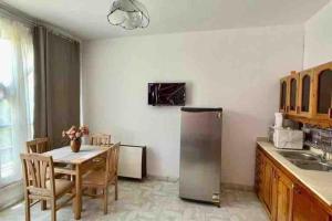 uma cozinha com uma mesa e um frigorífico de aço inoxidável em Palma de Meritee villa 2 apartment 4 village veiw em Hurghada