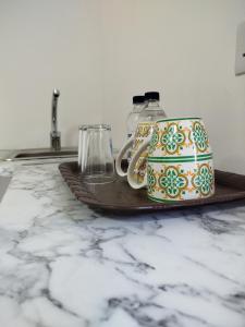 a cup and a mug on a plate on a counter at Limestone Sun Suites in Sliema