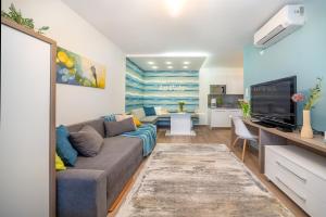 ein Wohnzimmer mit Couch und Fernseher in der Unterkunft La Vida apartman Hajdúszoboszló in Hajdúszoboszló