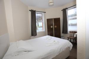 1 dormitorio con cama blanca y ventana en Charlie Hotel, en Londres