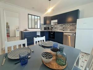 a kitchen with a table with two chairs and a bottle at Logement indépendant dans une longère in Grand Brassac