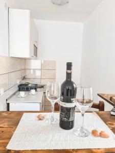 a bottle of wine sitting on a table with two wine glasses at Lemon&Olives in Budva