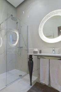 uma casa de banho com um chuveiro, um lavatório e um espelho. em Brera Prestige B&B em Milão