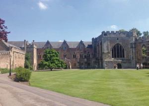 a large building with a grass field in front of it at Spindlewood Lodges in North Wootton