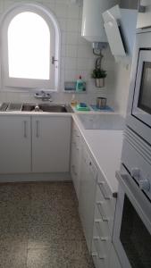 a white kitchen with a sink and a window at carpe diem beach front cat in Port de la Selva