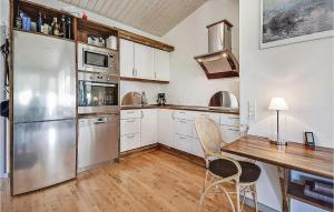 a kitchen with a table and a stainless steel refrigerator at Two-Bedroom Holiday Home Broager With A Fireplace 07 in Broager +4 photos