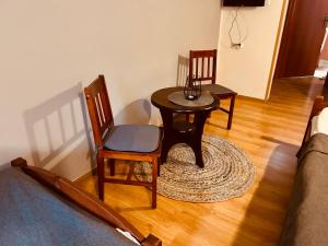 a small table and chairs in a living room at Domek w Lesie in Karłów