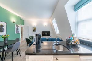 a kitchen with a sink and a living room at Kula London - Tower Bridge in London