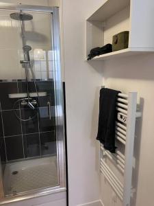 uma casa de banho com um chuveiro e um toalheiro. em « Le City » proche aéroport CDG, Parc Astérix, Disney, em Dammartin-en-Goële