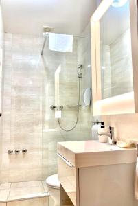 e bagno con doccia, servizi igienici e lavandino. di Hét Vezér Apartmanhotel a Komárom