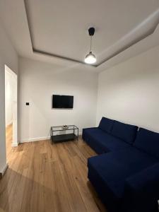 a living room with a blue couch and a tv at Cozy Corner in Rotterdam in Rotterdam