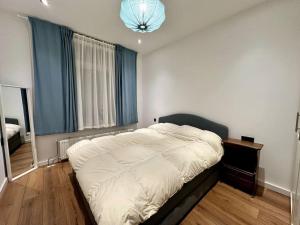 een groot bed in een slaapkamer met een groot raam bij Cozy Corner in Rotterdam in Rotterdam