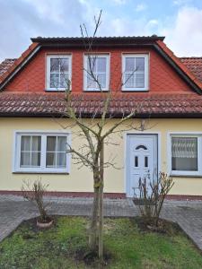 una casa con un árbol delante de ella en Emma en Greifswald