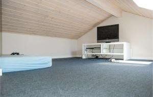 Skovbyにある3 Bedroom Beautiful Home In Sydalsのベッド1台、薄型テレビが備わる客室です。