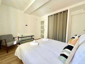 a bedroom with a large white bed and a chair at Sicardi 2 - Plage - Climatisation in Menton