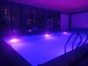 a swimming pool with lights in a dark room at Preluky in Bukovel