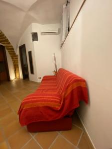 un letto in una camera con coperta rossa di Casa Carini a Sciacca