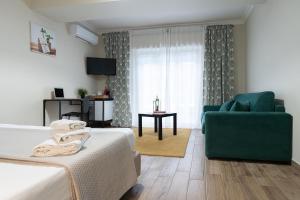 Habitación de hotel con cama y sofá verde en NeryHome Giardini Naxos, en Giardini Naxos