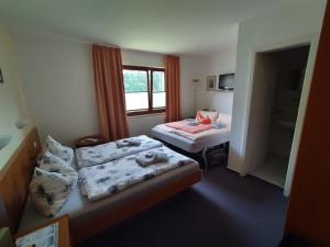 a hotel room with two beds and a window at Pension Stocker in Dierhagen