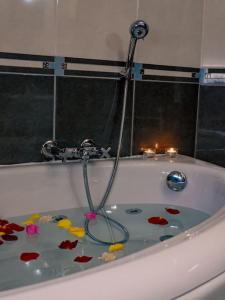 a bath tub with flowers in the water with candles at Papa’s house in Kalithies