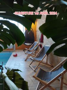 a row of lounge chairs in a room with a plant at Gite la Péraie - Le Chêne in Treize-Vents