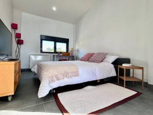 a bedroom with a bed and a flat screen tv at Blanca Mañana in Ribeira