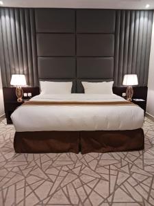Hotel and Apartments Al Raqi Mall Artiaad في تبوك: غرفة نوم مع سرير كبير مع اللوح الأمامي الأسود