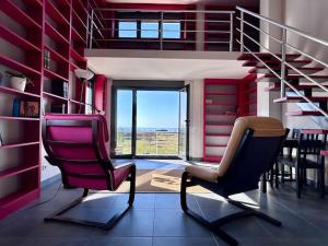 a living room with two chairs and a staircase at Blanca Mañana in Ribeira