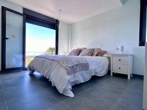 a white bedroom with a bed and a large window at Blanca Mañana in Ribeira +34 photos
