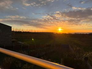 a sunset over a field with the sun setting at Blanca Mañana in Ribeira